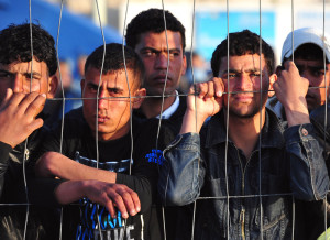 Tunisian migrants wait for the arrival of boats at Lampedusa on March 27, 2011. Hundreds of Tunisians have been moved to a tent camp set up in southern Italy that could house up to 3,300 people, local officials said, as anger against the migrants rose among locals. AFP PHOTO / ALBERTO PIZZOLI (Photo credit should read ALBERTO PIZZOLI/AFP/Getty Images)