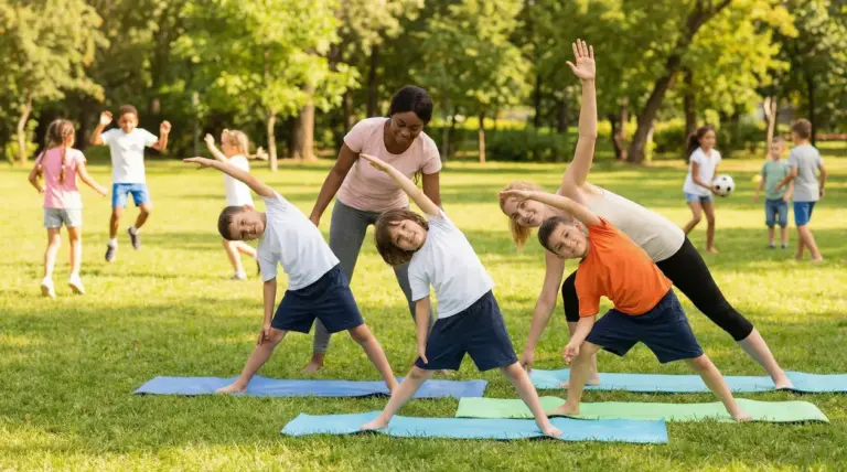 Bambini che fanno esercizi all'aperto guidati da adulti su tappetini da yoga in un parco